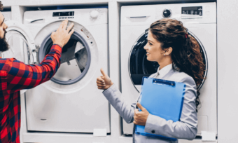 Woman selling new washing machine to man.