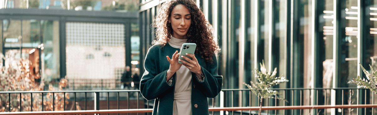 Young woman outdoors using green mobile phone