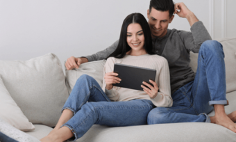 Young couple watching laptop together at home