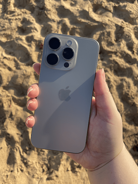 iPhone 15 Pro being held at beach