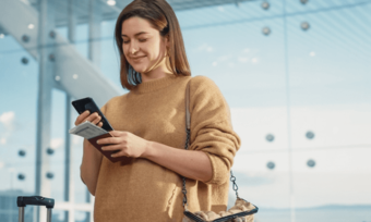 Woman using phone at airport. Keeping your number when overseas