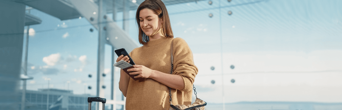 Woman using phone at airport. Keeping your number when overseas