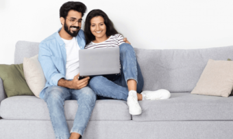 Happy couple using laptop at home