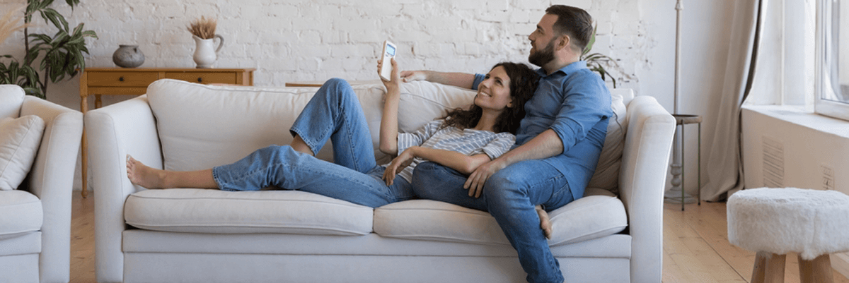 Happy couple using air conditioning at home