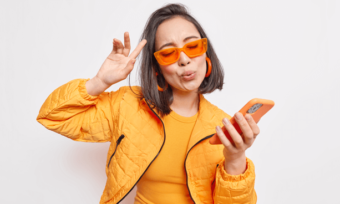 Amaysim sale - young woman using orange phone wearing orange outfit