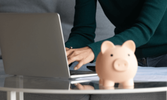 Woman using laptop and piggy bank. NBN prices concept