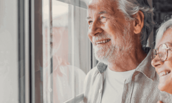 Senior couple smiling out a window