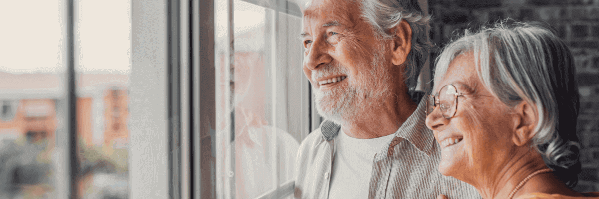 Senior couple smiling out a window