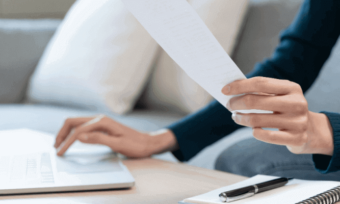 Woman reading bill and looking at laptop