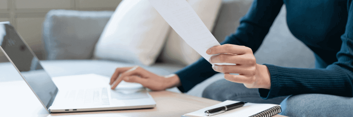 Woman reading bill and looking at laptop