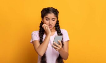 Young woman using phone, with concerned expression. Mobile plan concept