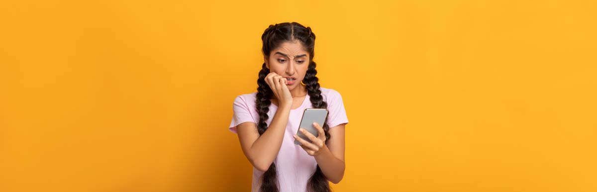 Young woman using phone, with concerned expression. Mobile plan concept